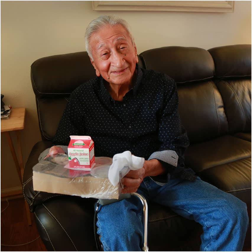 Mr Torres on his couch with his Meals on Wheels meal