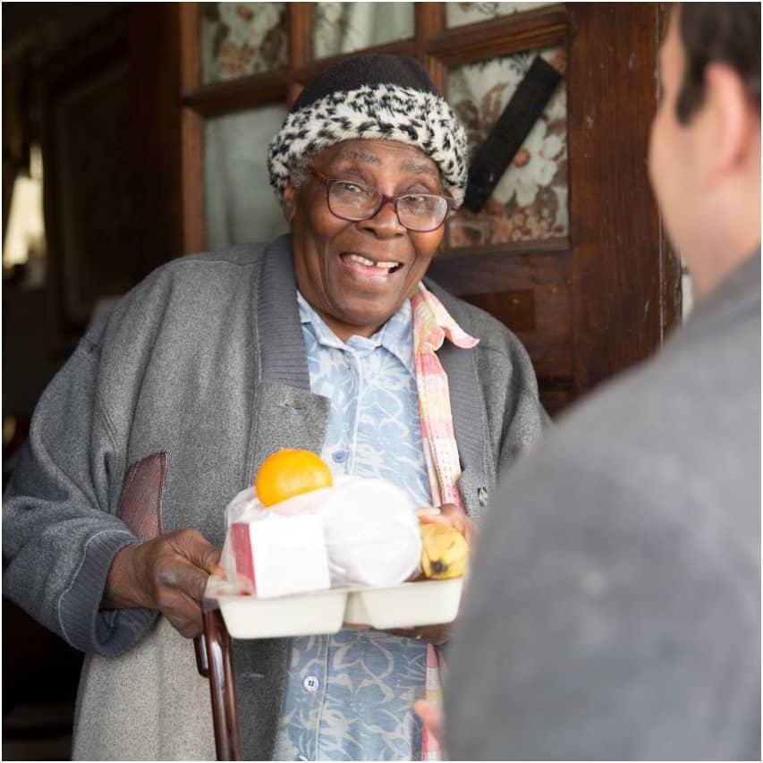 Happy Participant receiving her meal - your donations go a long way